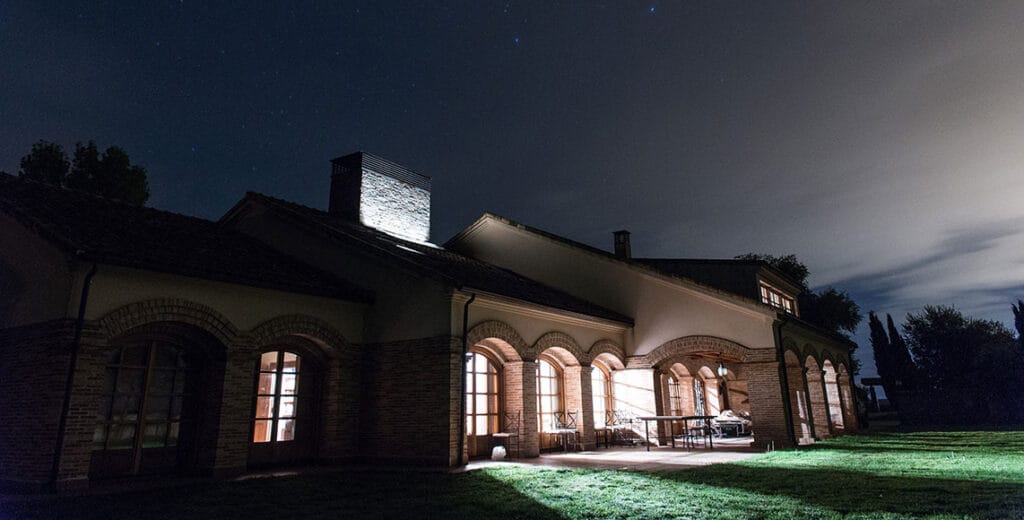 Exterior iluminado de casa rural exclusiva en Salamanca durante la noche